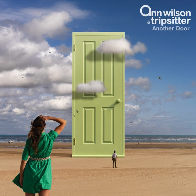 Person in a green dress standing on a beach with a large green door and clouds in the background, featuring 'Ann Wilson & Tripsitter' branding.